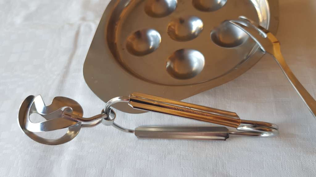 Stainless Steel Escargot dish with tongs and fork.