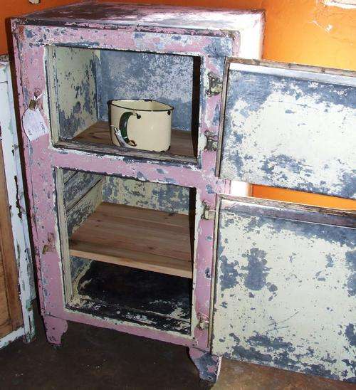 old metal FRIDGE converted for use as a cupboard