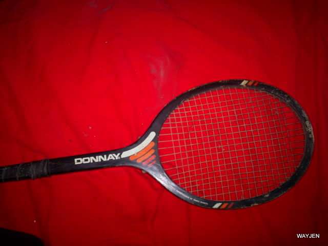DONNAY TENNIS RACQUET. THE HEAD OF THE RACQUET IS WARPED AND THERE IS A NAME ON THE NECK.