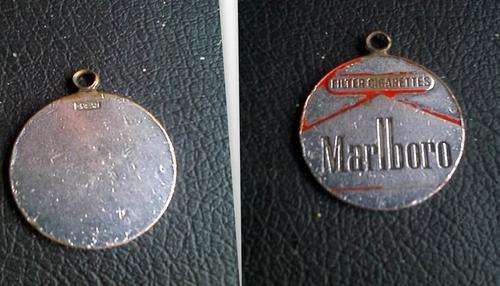 MARLBORO FILTER CIGARETTES METAL PENDANT. PLEASE NOTE THE CONDITION OF THE PENDANT.