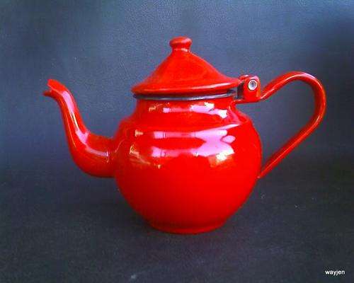 RETRO LOOKING RED TEA POT WITH HINGED LID. PLEASE NOTE WHAT LOOKS LIKE A BURN MARK IN FRONT.