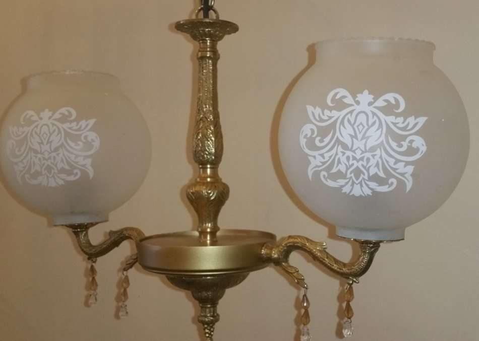 BRASS AND GILT TONE TWO ARM CHANDELIER WITH FROSTED GLASS SHADES