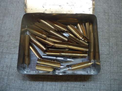 TIN OF BRASS WRITING PEN NIBS & A TIN LION OF FINEST QUALITY STEEL PINS