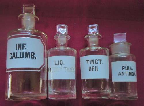 FOUR VINTAGE CLEAR GLASS CHEMIST-APOTHECARY BOTTLES + GLASS STOPPERS & WHITE LABELS  (LOG) SEE PICS