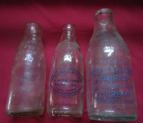 THREE DIFFERENT VINTAGE GLASS MILK BOTTLES -TWO PINT SIZE BOTTLES AND A QUART