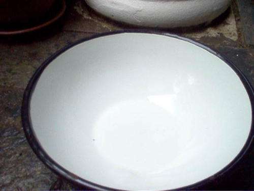 WHITE ENAMEL BOWL WITH BLACK TRIM.
