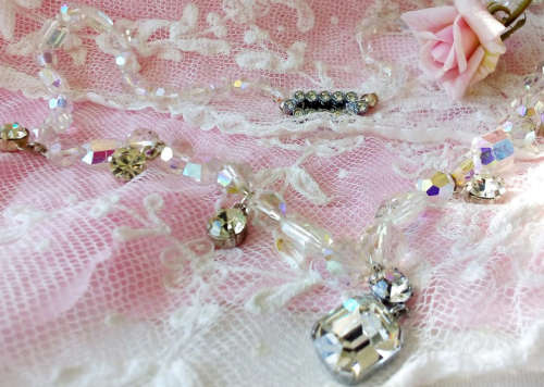 A SPARKLING SINGLE STRAND CRYSTAL NECKLACE WITH 6 SIDE DROP CRYSTALS AND A CENTRAL DROP PENDANT