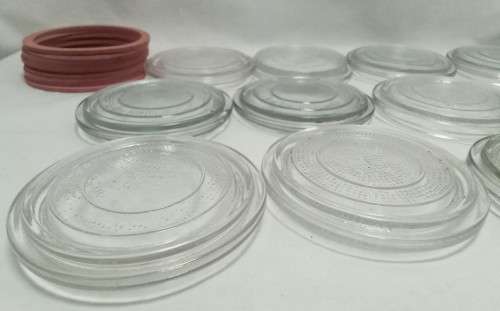 Twelve vintage Consol bottle glass lids & 10 elastic rings