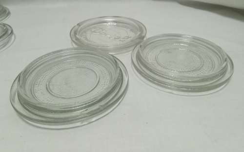 Twelve vintage Consol bottle glass lids & 10 elastic rings