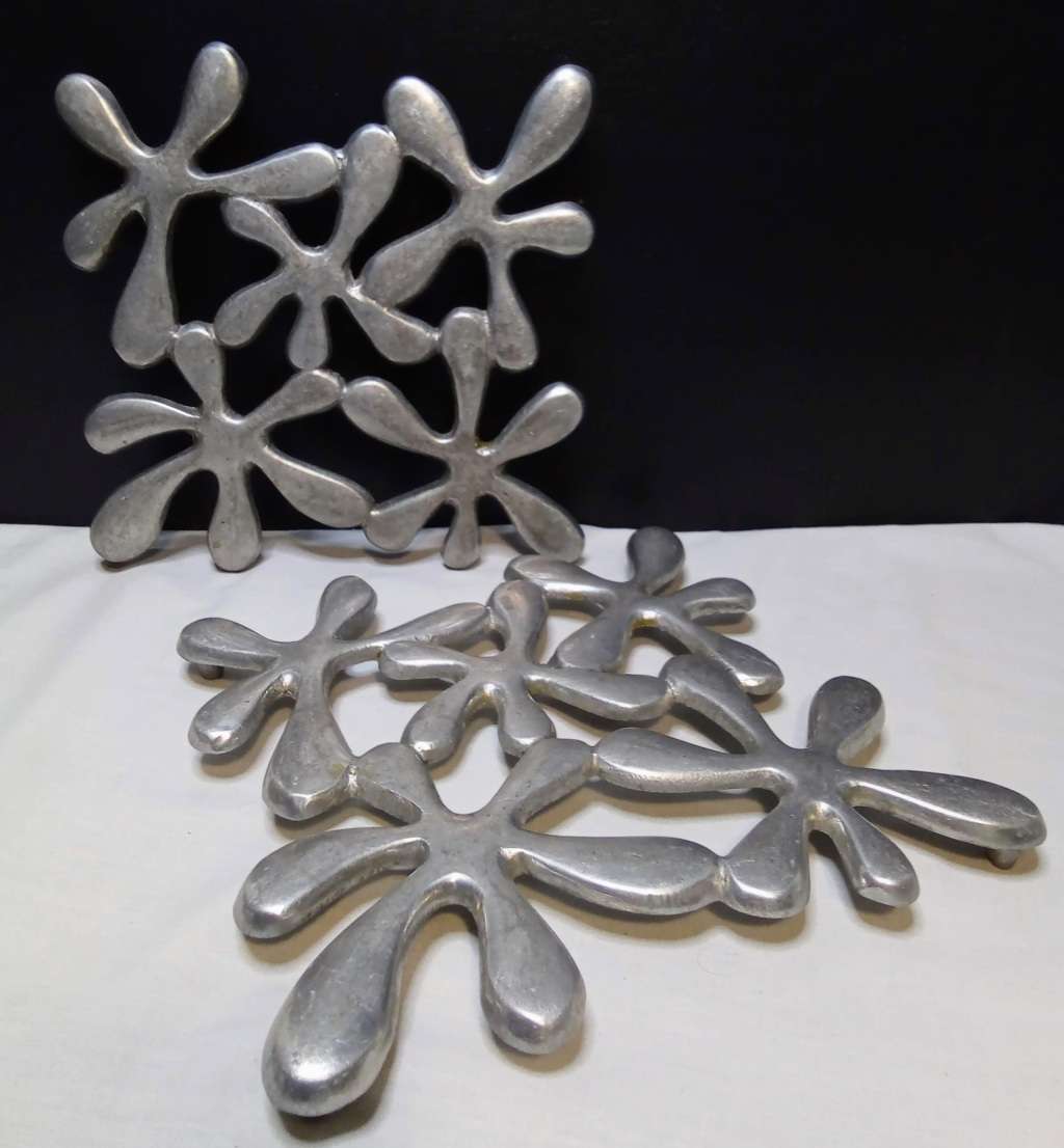 Two vintage aluminium trivets