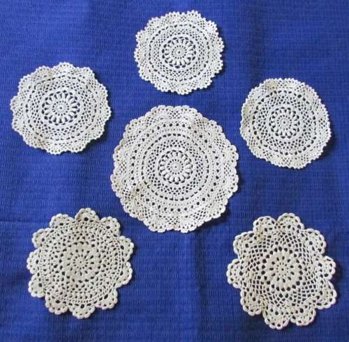 A SET OF 6 BEIGE ROUND DOILIES