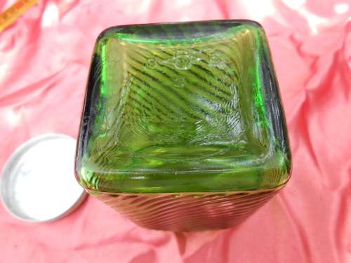 Green, ribbed-glass jar with metal lid.