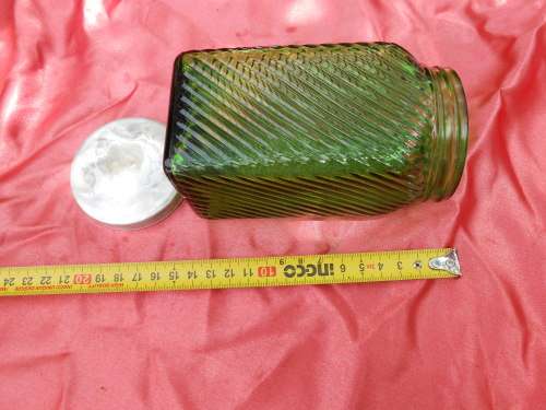Green, ribbed-glass jar with metal lid.