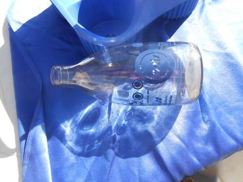 Three glass milk bottle in their plastic carrier.