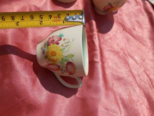 Susie Cooper.  Three saucers and six, SMALL, coffee cups.  No chips, cracks or repairs.