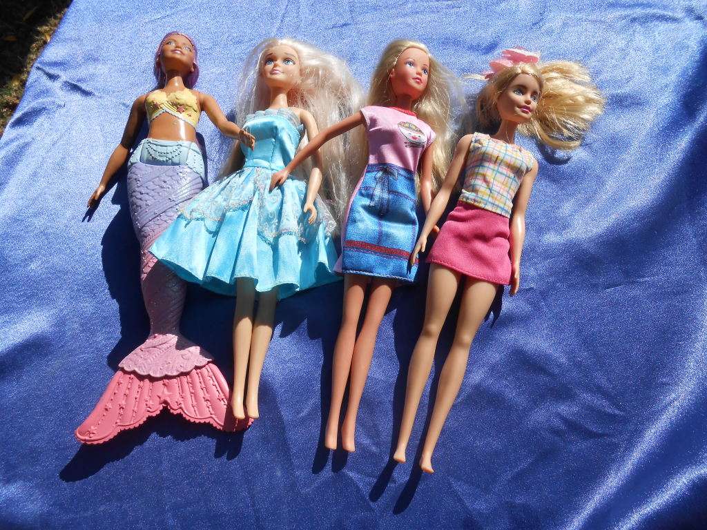 Four fashion dolls.  No markings.