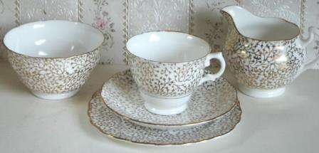 A place setting for five for tea, with Sugar Bowl and Milk Jug.  Crown Regent.