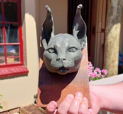 CARACAL (ROOIKAT) HENKMAM CLAY SCULPTURE WITH BRONZE COATING ON WOODEN WALL MOUNT