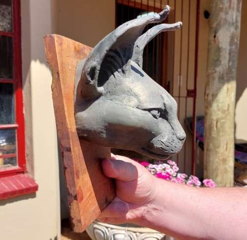 CARACAL (ROOIKAT) HENKMAM CLAY SCULPTURE WITH BRONZE COATING ON WOODEN WALL MOUNT