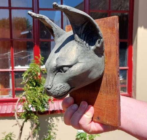CARACAL (ROOIKAT) HENKMAM CLAY SCULPTURE WITH BRONZE COATING ON WOODEN WALL MOUNT
