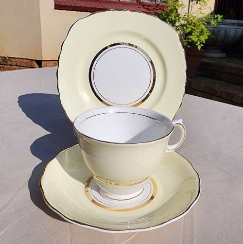 A WW2 ERA 1939 MARKED COLCOUGH CHINA TRIO IN HARLEQUIN BALLET LEMON YELLOW PATTERN (1ST OF 6)