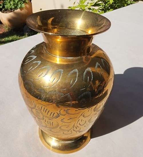 A BRASS VASE WITH LEAVE ENGRAVINGS