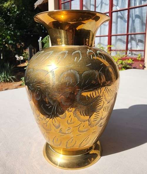 A BRASS VASE WITH LEAVE ENGRAVINGS