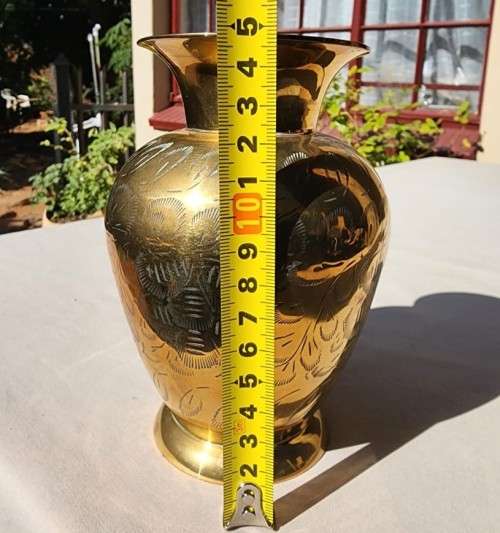 A BRASS VASE WITH LEAVE ENGRAVINGS
