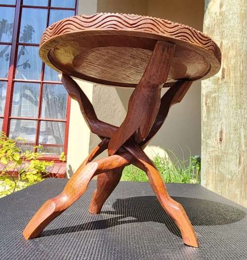 ORIENTAL TEAK COFFEE TABLE  CIRCULAR TOP WITH CARVED FLORAL BORDER AND FOLDING TRIPOD FEET