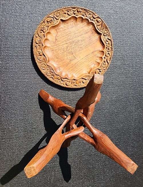 ORIENTAL TEAK COFFEE TABLE  CIRCULAR TOP WITH CARVED FLORAL BORDER AND FOLDING TRIPOD FEET