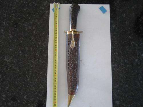 Steel knife with wooden scabbard and brass fittings.