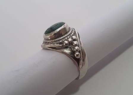 A fabulously decorated, solid sterling silver ring size M. Set with a cabochon green gem stone.