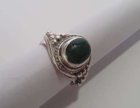 A fabulously decorated, solid sterling silver ring size M. Set with a cabochon green gem stone.