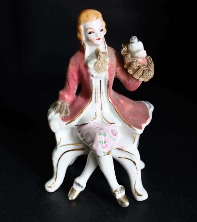 Porcelain Figurine of Man on Seat.