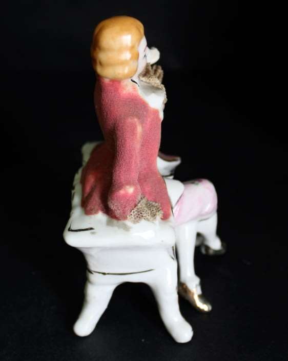 Porcelain Figurine of Man on Seat.