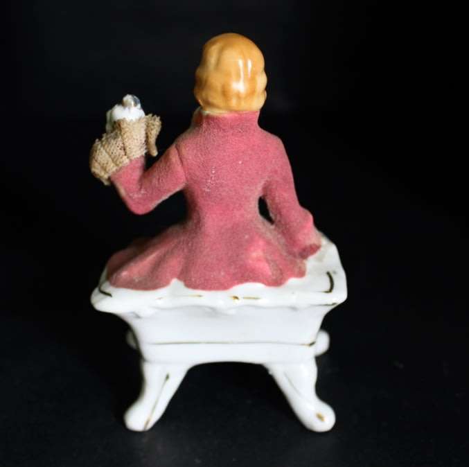 Porcelain Figurine of Man on Seat.