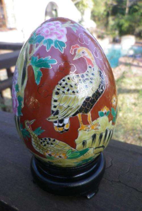 Pretty painted ceramic egg with pheasants and flowers on stand.