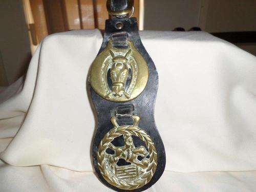 2 HORSE BRASSES ON BLACK LEATHER STRAP