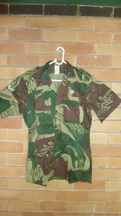 7B) A RHODESIAN SHORT SLEEVE-CAMO(BRUSHSTROKE) SHIRT WITH CORPORAL STRIPES & ARMY LABEL-NEVER WORN.