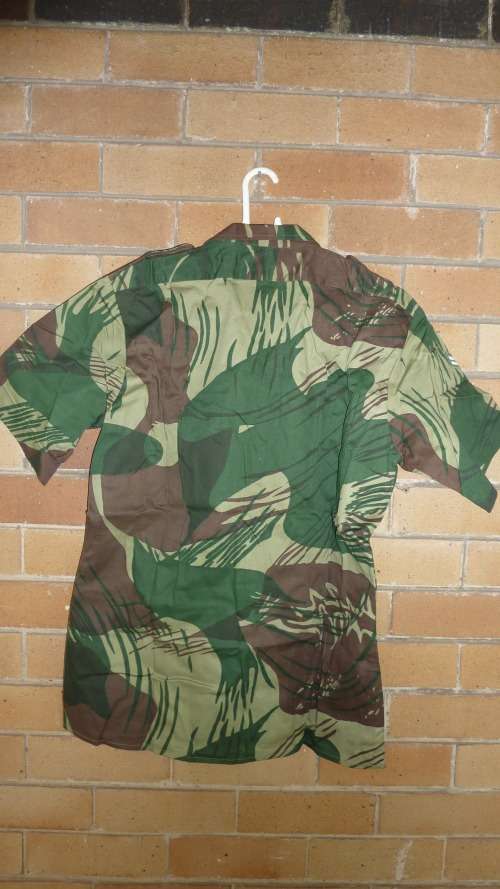 7B) A RHODESIAN SHORT SLEEVE-CAMO(BRUSHSTROKE) SHIRT WITH CORPORAL STRIPES & ARMY LABEL-NEVER WORN.