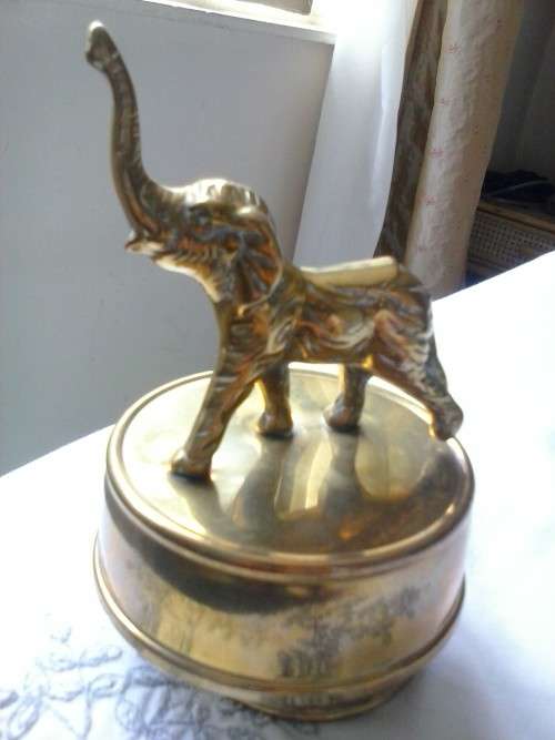 Small solid brass elephant on rotating musical stand, plays 'Tomorrow' from the movie Annie