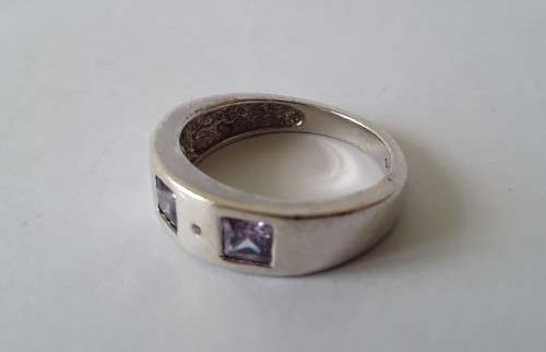 Solid sterling silver band ring with flush set purple stones. Size: N (17mm)