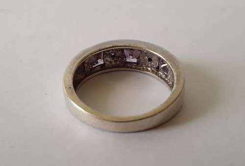 Solid sterling silver band ring with flush set purple stones. Size: N (17mm)