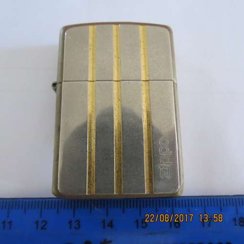 Brass Zippo lighter with silver and gold on it, as per photo
