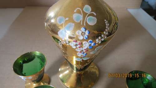 very attractive glass and guilt decanter with four glasses for liqueur, .............as per photo