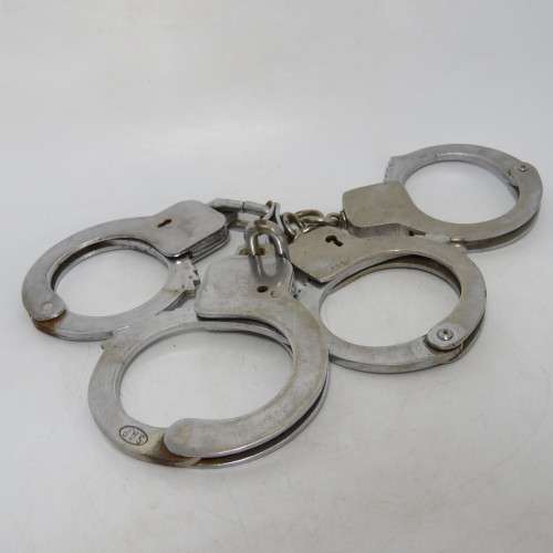 Two pairs of old SA Police handcuffs in pouch