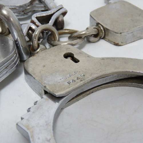 Two pairs of old SA Police handcuffs in pouch
