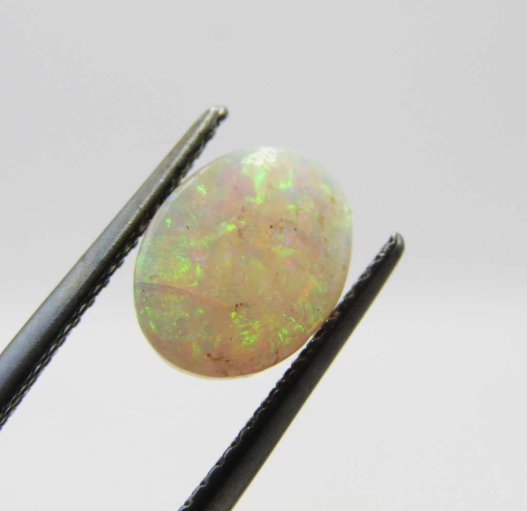 Beautiful orange & green flashes Opal of 1,21 carat - Oval Cabochon white opal