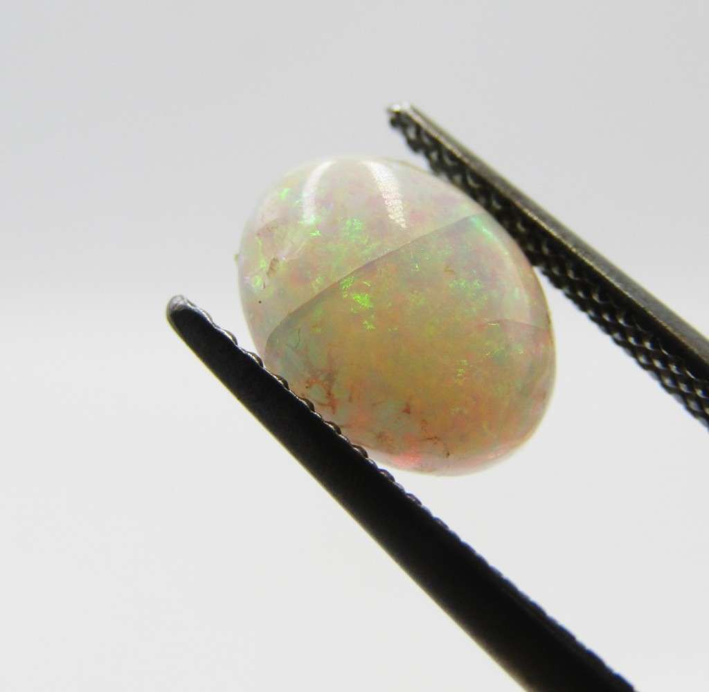 Beautiful orange & green flashes Opal of 1,21 carat - Oval Cabochon white opal
