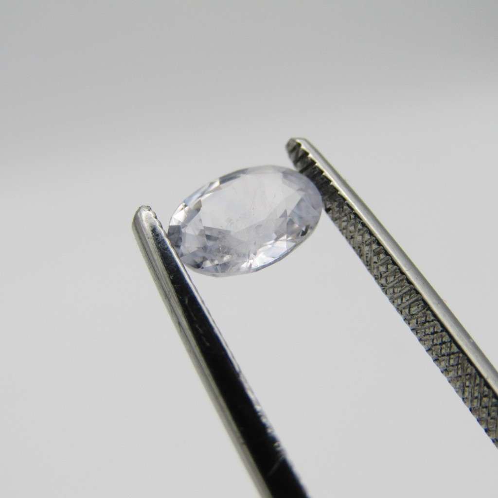 Natural Sapphire of 0,94 carat medium dark toned white - oval mixed cut with Gemlab certificate